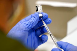 In this Oct. 5, 2021, file photo a healthcare worker fills a syringe with the Pfizer COVID-19 vaccine at Jackson Memorial Hospital in Miami. President Joe Biden’s most aggressive move yet to combat the COVID-19 pandemic is almost ready to see the light of day. The government is close to publishing the details of a new vaccination-or-testing rule covering more than 80 million Americans at companies with 100 or more workers.