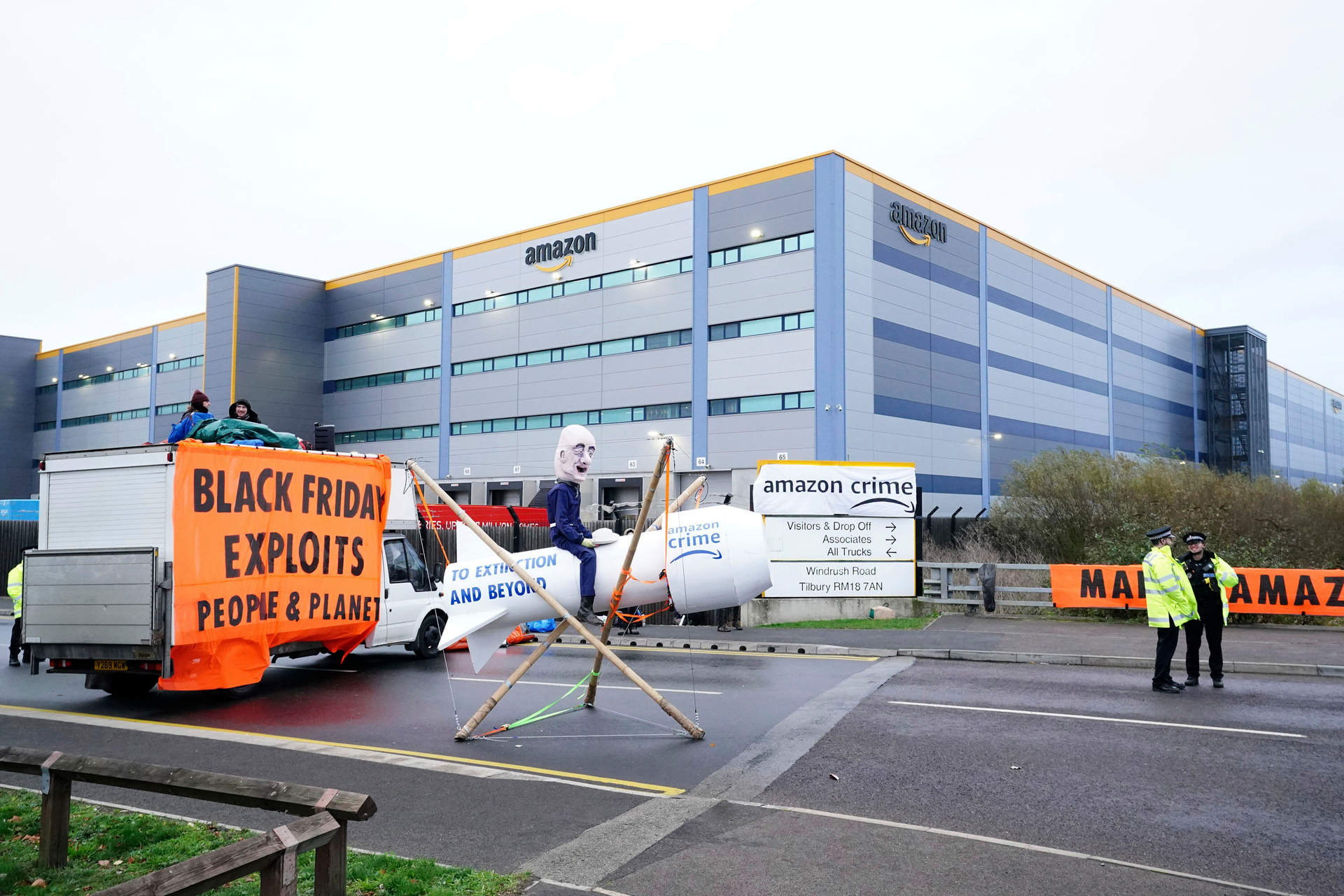 Activists from Extinction Rebellion block the entrance to an Amazon fulfillment center, Tilbury, England, Nov. 26, 2021.