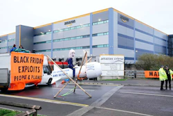 Activists from Extinction Rebellion block the entrance to an Amazon fulfillment center, Tilbury, England, Nov. 26, 2021.