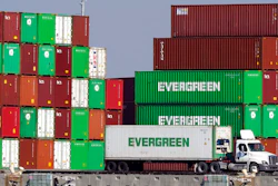 Shipping containers are stacked over a truck at the Port of Los Angeles Wednesday, Nov. 10, 2021, in Los Angeles. One month after President Joe Biden announced an agreement to have the Port of Los Angeles operate round-the-clock to help break a cargo backlog at the docks, officials disclose that hasn’t happened as they contend with a shortage of truck drivers and accessible warehouse space.