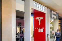 This photo made Wednesday, Feb. 24, 2021, shows people walking by the entrance to a Tesla store at a shopping mall in Pittsburgh. Tesla shares slumped about 5% in premarket trading after its CEO Elon Musk said he would sell 10% of his holdings — about $20 billion worth — in the electric car maker based on the results of a poll he conducted on Twitter over the weekend.