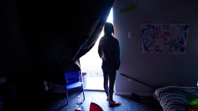 In this Feb. 23, 2021, file photo, Ricki Mills looks out from her home as she waits for a fire hydrant to be turned to get water, in Dallas on Feb. 23, 2021. Texas is again at high risk of power blackouts this winter because of extreme weather like the catastrophic February storm that buckled the state's electric grid and left millions of people without heat for days, regulators said Thursday, Nov. 18, 2021.