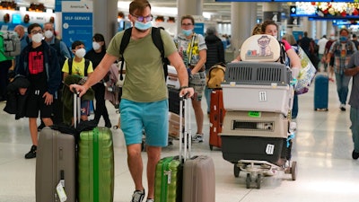 A family and their pets walk through Miami International Airport, on Dec. 20, 2021, in Miami.