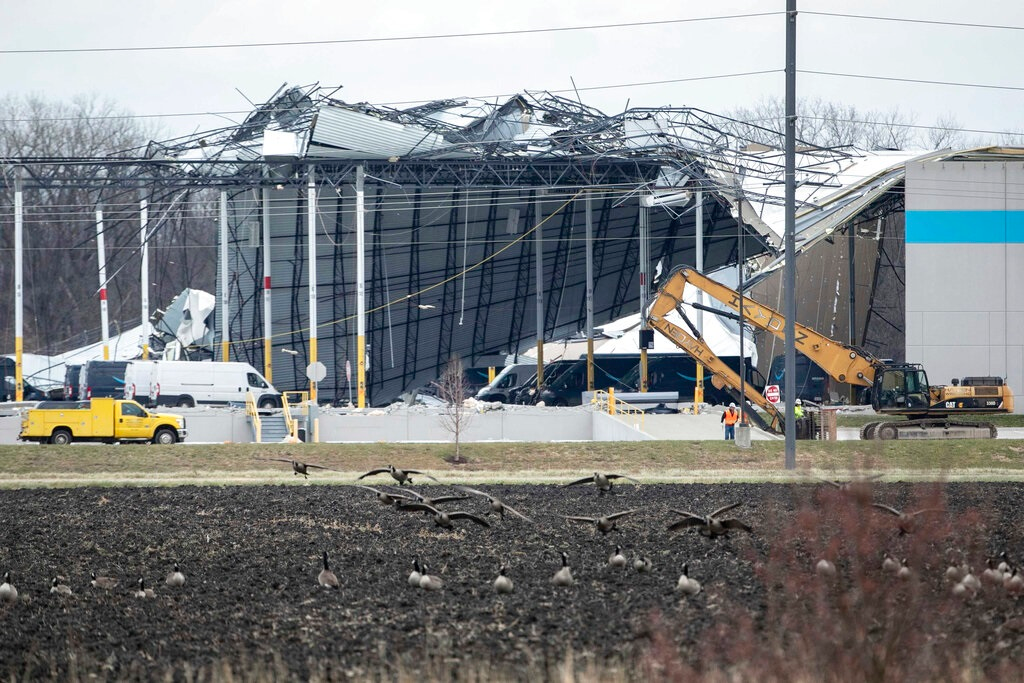 Crews move in heavy equipment for search and rescue operations at the Amazon distribution center in Edwardsville, Ill., on Saturday, Dec. 11, 2021. Overnight severe storms caused the building to partially collapse with confirmed fatalities according to police. The roof of the building was ripped off and a wall about the length of a football field collapsed.