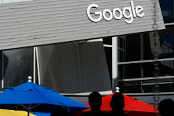 People walk by a Google sign on the company's campus in Mountain View, Calif., on Sept. 24, 2019. Google and Ford Co. are among those once again delaying their return-to-office plans, while other businesses whose workers are already back to the office are considering adding extra precautions like masks and doing COVID-19 testing.