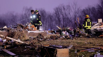 Firefighters search a debris field that came from a house that was ripped off its foundation and trees were cut off after a tornado ripped along Highway F at the intersection of Stub Road in St. Charles County, Mo., on Friday, Dec. 10, 2021.