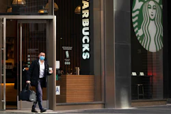 A man carries a beverage as he walks out of a Starbucks coffee shop on Jan. 19, 2021 in New York.
