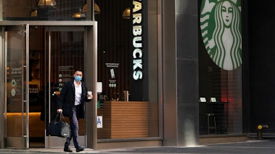 A man carries a beverage as he walks out of a Starbucks coffee shop on Jan. 19, 2021 in New York.