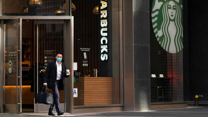 A man carries a beverage as he walks out of a Starbucks coffee shop on Jan. 19, 2021 in New York.