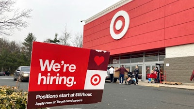 A hiring sign is in front of a Target store in Manchester, Conn., Nov. 39, 2021. Workers at Target stores and distribution centers in places like New York, where competition for finding and hiring staff is the fiercest, could see starting wages as high as $24 an hour this year. The Minneapolis-based discount retailer said Monday, Feb. 28, 2022 that it will adopt minimum wages that range from $15 to $24 an hour, with the highest pay going to hires in the most competitive markets. It currently pays a universal starting wage of $15 an hour.