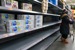 A woman looks over shelves, some of which are empty, at a Walmart store in Teterboro, N.J., on Jan. 12, 2022. The Justice Department is launching a new initiative aimed at identifying companies that exploit supply chain disruptions in the U.S. to make increased profits in violation of federal antitrust laws.