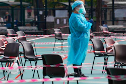 A health worker wearing protective gear waits for residents to be tested for the coronavirus at a temporary testing center in Hong Kong on Feb. 28, 2022.