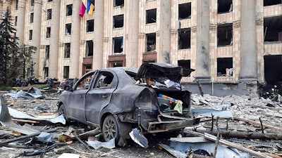 In this handout photo released by Ukrainian Emergency Service, a burnt car is seen in front of a damaged City Hall building, in Kharkiv, Ukraine on March 1, 2022.