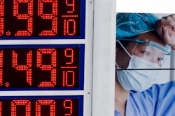 Prices are displayed on a sign at a gas station in Milwaukee on March 14, 2022, with a billboard for medical services in the background.
