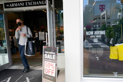 For sale and hiring signs are displayed at an Armani Exchange store, Friday, Jan. 21, 2022, in Miami Beach, Fla.