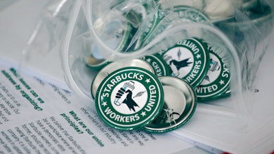 Pro-union pins on a table during a watch party for Starbucks' employees union election, Dec. 9, 2021, Buffalo, N.Y.