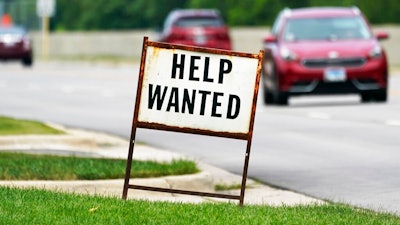 A help wanted sign is displayed at a gas station in Mount Prospect, Ill., Tuesday, July 27, 2021. Fewer Americans applied for unemployment benefits last week as layoffs remain at historically low levels. Jobless claims fell by 5,000 to 166,000 for the week ending April 2, 2022 the Labor Department reported Thursday.
