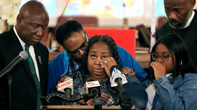 Deon January, center, wipes tears from her eyes as she talks about her son DeAndre Morrow during a news conference in Edwardsville, Ill., May 3, 2022.