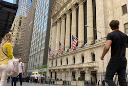 Pedestrians walk by the New York Stock Exchange, May 18, 2022.