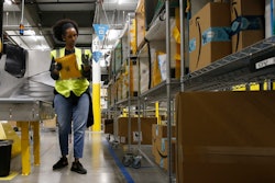 Tahsha Sydnor sorts packages at an Amazon warehouse, Goodyear, Ariz., Dec. 17, 2019.