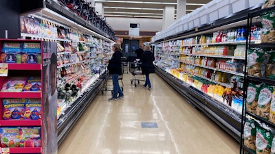 Customers shop at a grocery store in Mount Prospect, Ill., April 1, 2022.