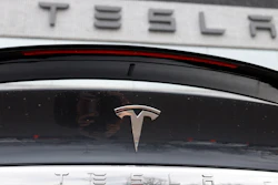 In this April 26, 2020 photo, the company logo shines off the rear deck of an unsold 2020 Model X at a Tesla dealership in Littleton, Colo. Tesla’s sales from April through June 2022 fell to their lowest quarterly level since last fall as supply chain issues and pandemic restrictions in China hobbled production of its electric vehicles.