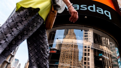 People walk past the Nasdaq MarketSite, New York, July 13, 2022.