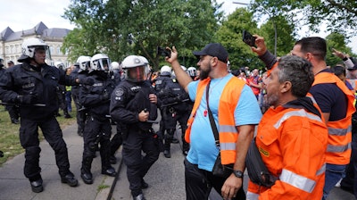 Police officers are pushed back by demonstrators after the arrest of a participant in a demonstration by port workers, Hamburg, Germany, July 15, 2022.