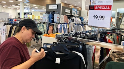 A customer checks price tags while shopping at a store in Schaumburg, Ill., June 30, 2022.