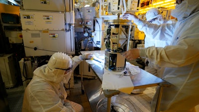 Technicians inspect a piece of equipment during a tour of the Micron Technology automotive chip manufacturing plant Feb. 11, 2022, in Manassas, Va. A bill to boost semiconductor productionin the United States is making its way through the Senateis atop priority of the Biden administration. It would add about $79 billion to the deficit over 10 years, mostly as a result of new grants and tax breaks that would subsidize the cost that computer chip manufacturers incur when building or expanding chip plants in the U.S.