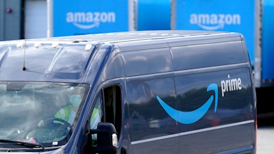 A delivery van departs an Amazon Warehouse in Dedham, Mass., Oct. 1, 2020.