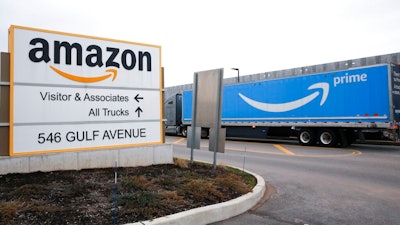 An Amazon Prime truck passes by a sign outside an Amazon fulfillment center on Staten Island, New York, on March 19, 2020. Amazon is heading into its annual Prime Day sales event on Tuesday, July 12, 2022, much differently than how it entered the pandemic. Once the darling of the pandemic economy, the company posted a rare quarterly loss in April as well as its slowest rate of revenue growth in nearly two decades at 7%.
