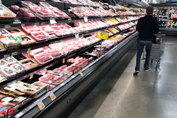 A shopper pushes his cart past a display of packaged meat in a grocery store, Denver, May 10, 2020.