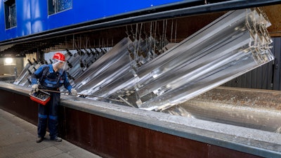 A worker moves hot-dip galvanized metal pieces at Zinkpower, Meckenheim, Germany, Aug. 18, 2022.