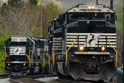 A Norfolk Southern freight train passes a train as it approaches a crossing, Homestead, Pa., April 27, 2022.
