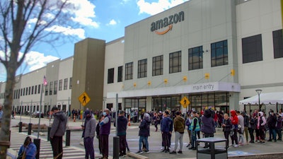 In this image from video, Amazon workers line up outside the company's facility in Staten Island, New York, March 25, 2022.
