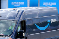 An Amazon Prime logo appears on the side of a delivery van as it departs an Amazon Warehouse location in Dedham, Mass., Oct. 1, 2020.