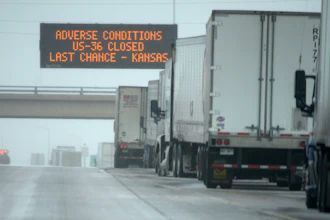 Tractor-trailers stacked up along eastbound lanes of Interstate 70 near East Airpark Road, Aurora, Colo., Dec. 13, 2022.
