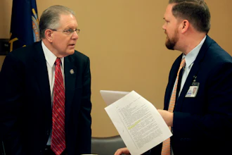Kansas Sen. Mike Thompson, R-Shawnee, confers with Jason Long, an attorney on the Legislature's bill drafting staff, before a committee meeting at the Statehouse in Topeka, March 7, 2023.