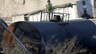 A cleanup worker stands on a derailed tank car of a Norfolk Southern freight train in East Palestine, Ohio, Feb. 15, 2023.
