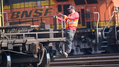 A worker rides a rail car at a BNSF rail crossing in Saginaw, Texas, Wednesday, Sept. 14, 2022. Tens of thousands of engineers remain frustrated with the lack of paid sick time and the demands railroads like BNSF are making in negotiations despite the progress that has been made in 2023 with sick time deals for most of the other rail unions.