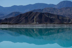 Mountains and a liming facility are reflected in a brine evaporation pond at Albemarle Corp.'s Silver Peak lithium facility, on Oct. 6, 2022, in Silver Peak, Nev.