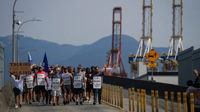 Striking workers march as gantry cranes sit idle, Vancouver, July 6, 2023.