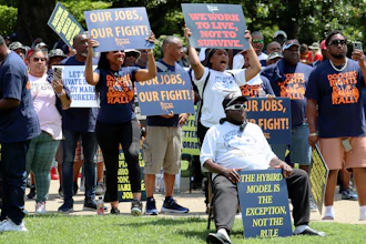 Workers hold signs supporting labor organizers at a rally in Columbia, S.C., July 12, 2023.