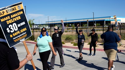Workers picket outside an Amazon distribution center in Palmdale, Calif., July 24, 2023.