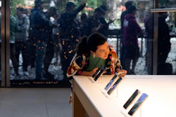 A woman looks at Apple's new iPhone 15 at an Apple Store in Los Angeles, Sept. 22, 2023.