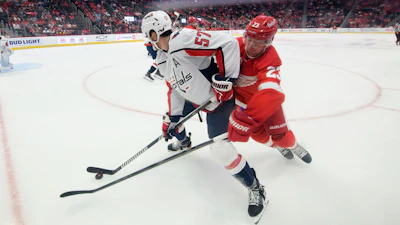 Detroit's Lucas Raymond tries to steal the puck from Washington's Trevor van Riemsdyk a Capitals-Red Wings preseason game, Detroit, Sept. 30, 2023.