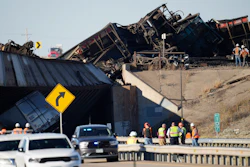 Workers clear cars that derailed in an accident over Interstate 25 north of Pueblo, Colo., Oct. 16, 2023.
