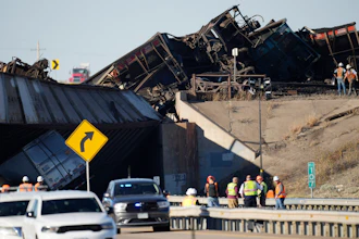 Workers clear cars that derailed in an accident over Interstate 25 north of Pueblo, Colo., Oct. 16, 2023.