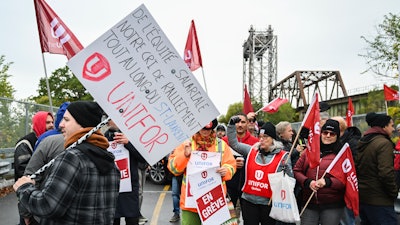 Striking workers picket outside the St. Lambert Lock in St. Lambert, Quebec, Oct. 23, 2023.